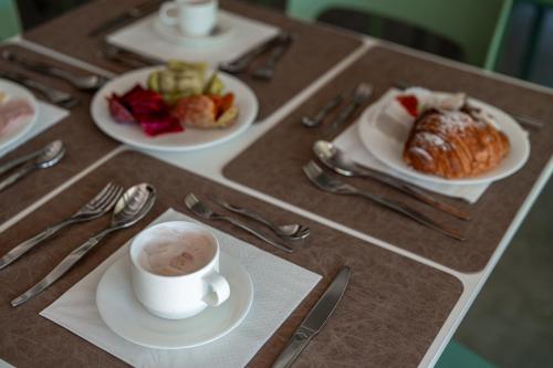 a table with plates of food and a cup of coffee at Manfredomus in Mussomeli