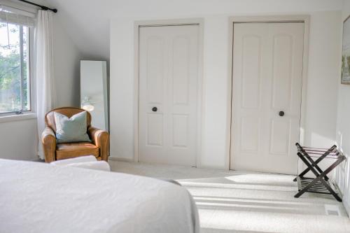 a bedroom with a bed and a chair and a mirror at Annapolis Charm Waterfront Getaway Near USNA - FISH & CRAB from your PRIVATE PIER! in Annapolis