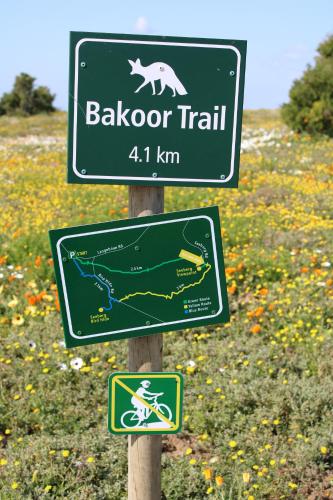 a sign for a trail with a bear and a map at Windward - Visit Langebaan in Langebaan