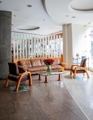 a lobby with a couch and a table and chairs at El Dorado Hotel in Cuenca