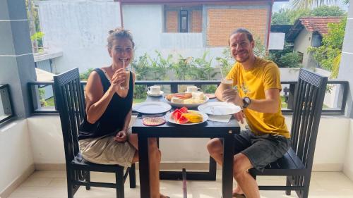 a man and woman sitting at a table eating food at Erin Orr Villa in Wadduwa