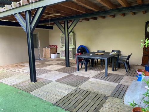 un patio avec une table et des chaises sur une terrasse dans l'établissement Les pieds dans l eau, à Belfort