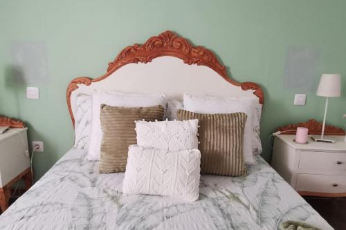 a bedroom with a bed with white sheets and pillows at La Casita de Coco Tejeda in Tejeda