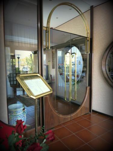 a mirror on the side of a building with a table at Hotel Internazionale in Cervignano del Friuli