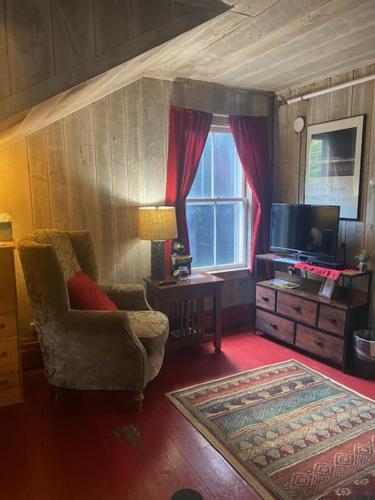 a living room with a chair and a television at Wildcat Inn and Tavern in Jackson