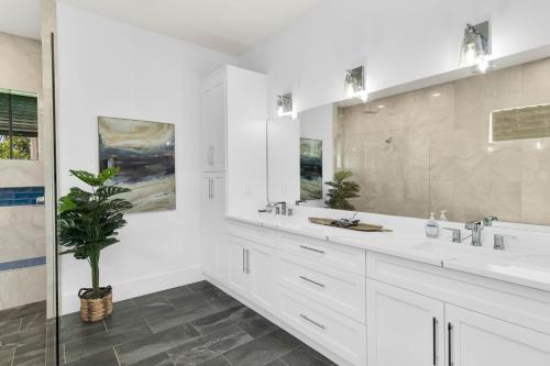 a white bathroom with two sinks and a mirror at New Listing I Luxurious Waterfront 4 Bed Island Retreat in Marco Island