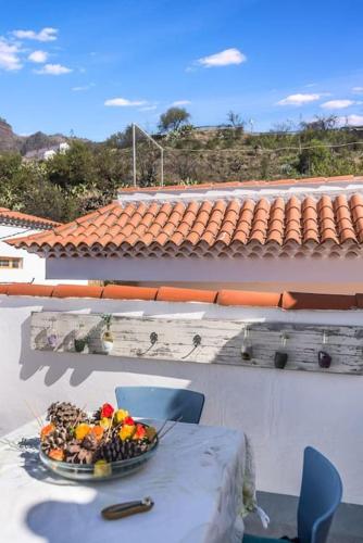 a bowl of fruit on a table on a balcony at La Casita de Coco Tejeda in Tejeda