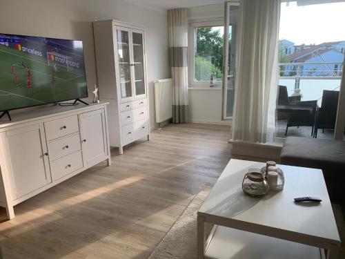 a living room with a flat screen tv and a couch at ZingstUrlauber in Zingst
