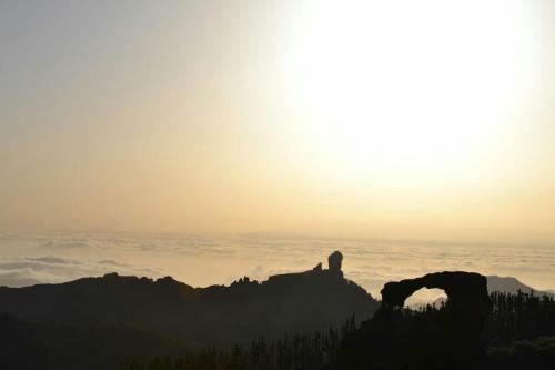 a person standing on top of a mountain at sunset at La Casita de Coco Tejeda in Tejeda