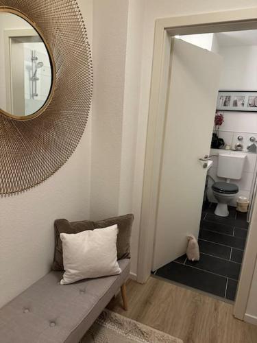 a bathroom with a mirror and a couch and a toilet at Ruhige Stadtperle mit Garten in Wiesbaden