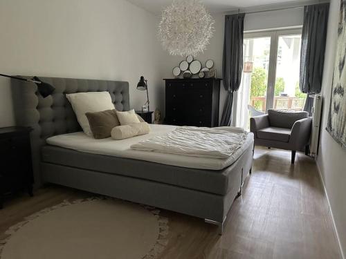 Un dormitorio con una cama y una silla y una ventana. en Ruhige Stadtperle mit Garten, en Wiesbaden