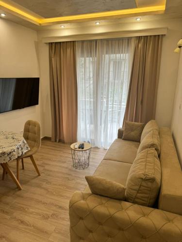 a living room with a couch and a table at Alex Apartments ,50m from the sea,FREE PRIVATE PARKING in Dobrota
