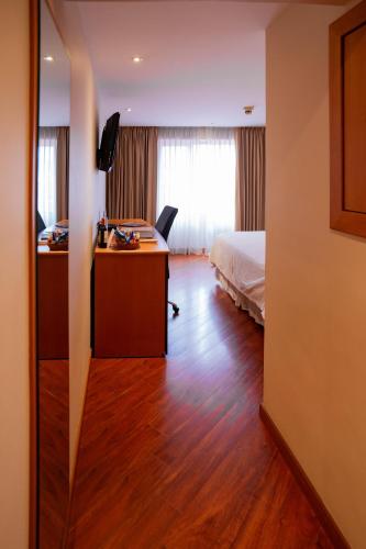 a hotel room with a bed and a desk and a bedroom at El Dorado Hotel in Cuenca