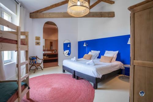 une chambre avec deux lits et un mur bleu dans l'établissement Mas Evalla, Charme, Piscine Chauffée et Vue Unique, à Saint-Pons-la-Calm