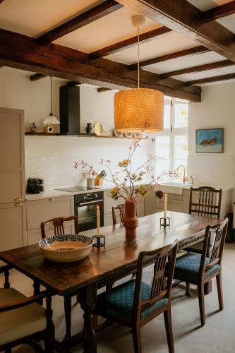 a kitchen with a wooden table with chairs and a dining room at Landgoed Frymerson in Sint Odiliënberg