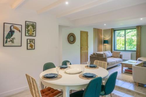 un salon avec une table et des chaises blanches dans l'établissement Proche ORLEANS - Maison 2 chambres - Accès direct au Bord du Loiret, à Saint-Hilaire-Saint-Mesmin