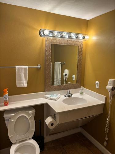 ein Badezimmer mit Waschbecken, Toilette und Spiegel in der Unterkunft Beach Front Condo in Panama City Beach in Panama City Beach