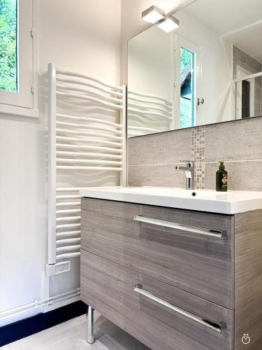 une salle de bain avec un lavabo et un miroir dans l'établissement La Verdoyante -Tennis Piscine-Proche Pont L'Evêque, à Surville