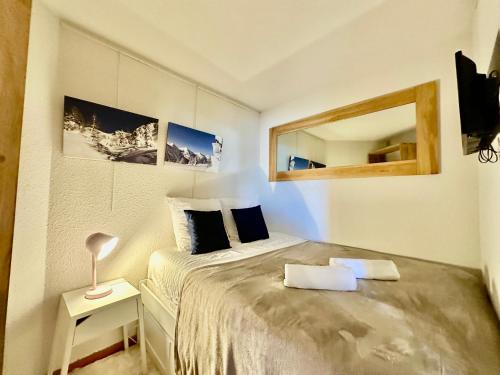 une petite chambre avec un lit et un miroir dans l'établissement 4 Seasons for 8 persons with Sauna and Local Ski, à Isola