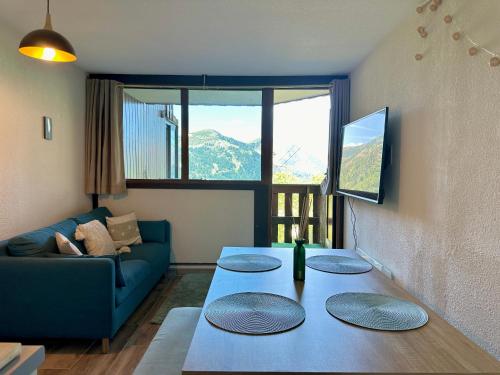 un salon avec un canapé bleu et une table dans l'établissement 4 Seasons for 8 persons with Sauna and Local Ski, à Isola