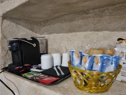 a counter with a basket of cups and a coffee maker at Luxy Gargano Suite in San Giovanni Rotondo