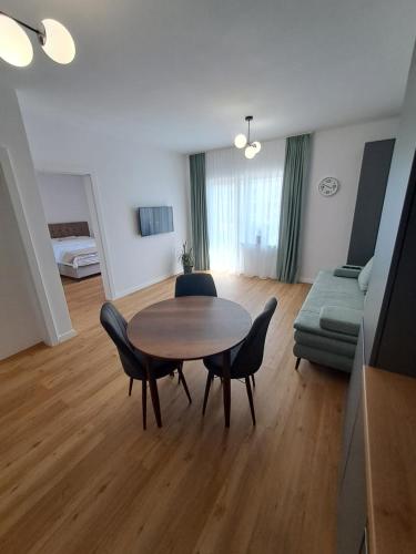 Una sala de estar con una mesa y sillas y un sofá. en Studio Elisabeth, en Şelimbăr