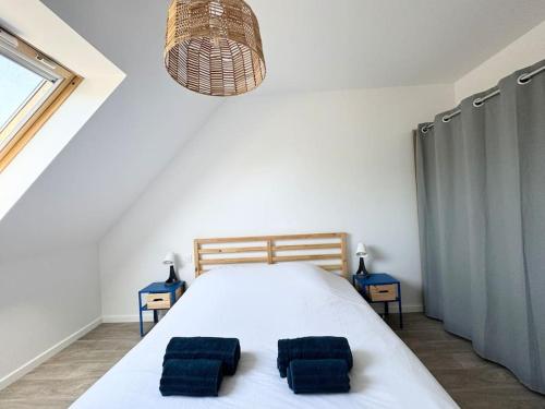 a bedroom with a bed with two pillows on it at La baie, maison neuve proche des plagesMaison neuve, proche des plages, Mousterlin in Fouesnant