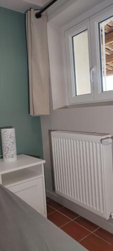 une cuisine avec un radiateur blanc et une fenêtre dans l'établissement La Bastide, Chambre d'hôtes, à Castagniers