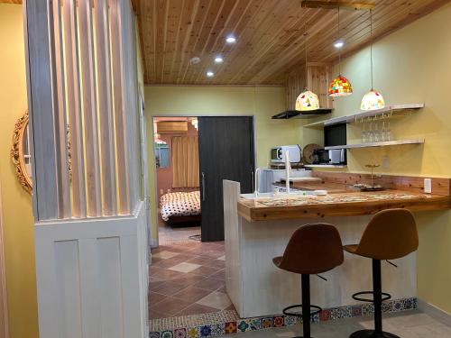 a kitchen with two stools at a counter in a room at 若狭の家 in Naha