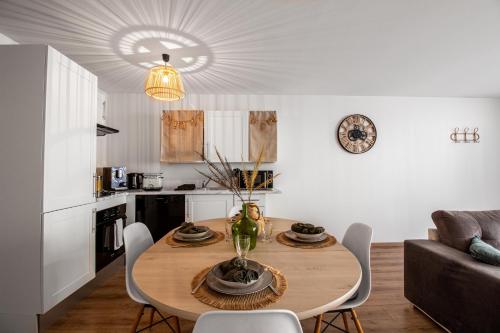 une cuisine et une salle à manger avec une table et des chaises dans l'établissement Sweet-Cozy, à Knutange