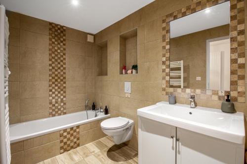 une salle de bain avec un lavabo, des toilettes et une baignoire dans l'établissement Sweet-Cozy, à Knutange