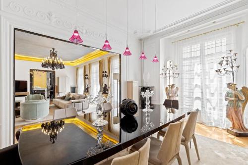 une salle à manger avec une table et un grand miroir dans l'établissement Spectacular 3BR Luxury Residence - Arc de Triomphe, 264m2, à Paris