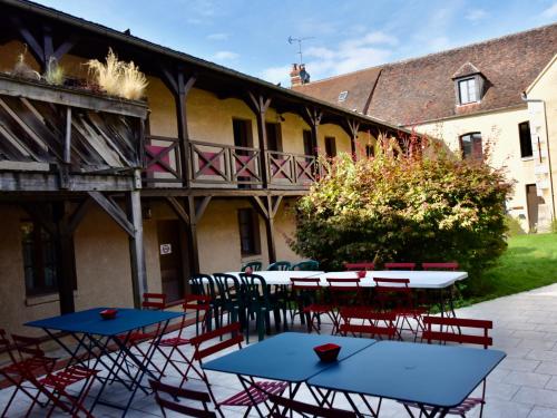 a group of tables and chairs in front of a building at Le Relais du Château in Saint-Fargeau