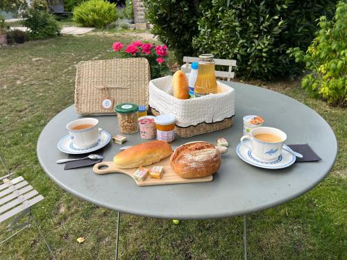 Casa Verde by La Boîte En Plus في سونلي: طاولة مع صينية من الخبز وكوبين من القهوة