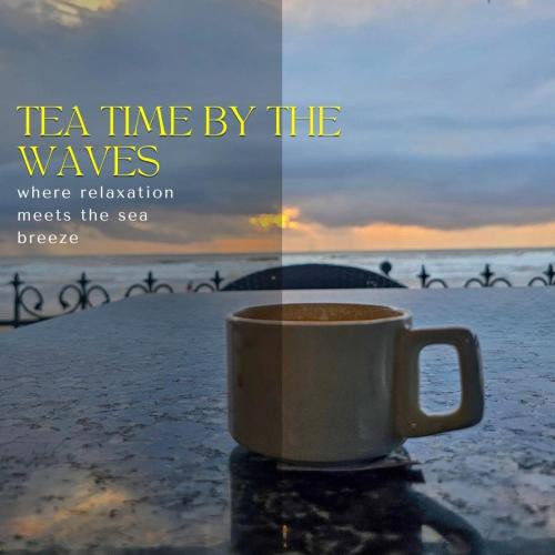 a coffee cup sitting on the beach with the words tea time by the waves at Arthigamya Beach Front Resort & SPA in Gokarna