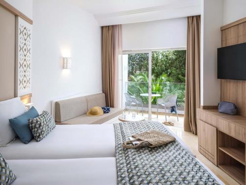 a hotel room with a bed and a large window at TUI BLUE Palm Beach Hammamet - All inclusive in Hammamet