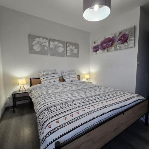 une chambre avec un grand lit avec deux oreillers dans l'établissement Le Contemporain, à Ville-la-Grand