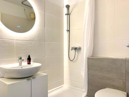 a white bathroom with a sink and a shower at Cozy one bedroom apartment in Augsburg in Augsburg