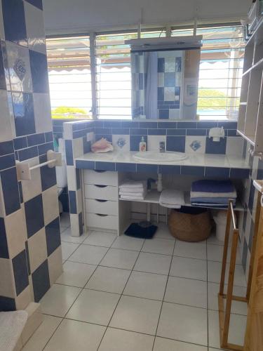 a blue and white bathroom with a sink at La Sucrière in Terre-de-Haut
