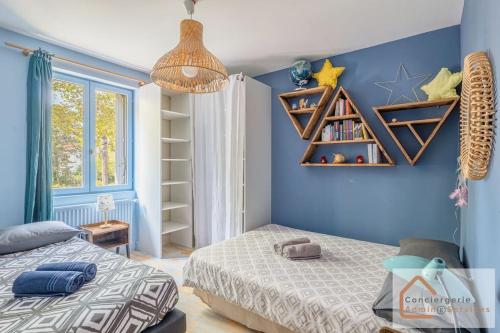 une chambre avec un lit et un mur bleu dans l'établissement Maison à Lyon Parilly avec Piscine, Jardin, Parking Privé & Proche Eurexpo, à Vénissieux