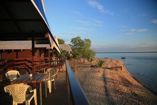 a restaurant with a table and chairs next to the water at Crab Claw Island in Bynoe Harbour