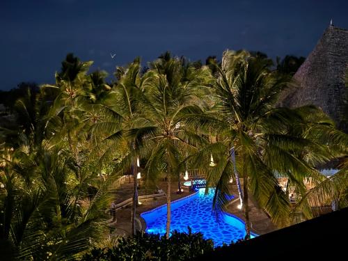 an overhead view of a swimming pool with palm trees at Aquarius Club in Watamu