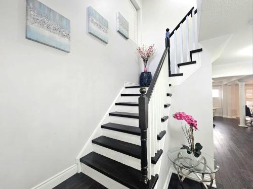 a staircase with white walls and a black and white stair case at Beautiful 3 bedroom Entire detached home in Whitby