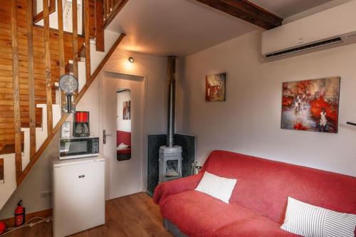 - un salon avec un canapé rouge et un escalier dans l'établissement Gite bien-être hammam et jacuzzi ,sauna, à La Grotte