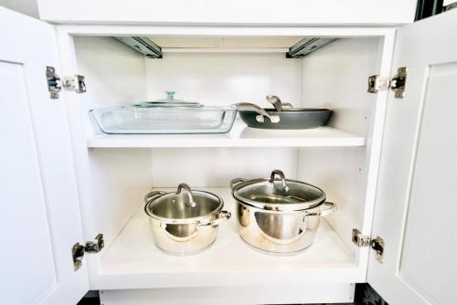 two pots and pans in a kitchen cabinet at 10 Bedroom Historical Downtown Albany Pet Friendly Home in Albany