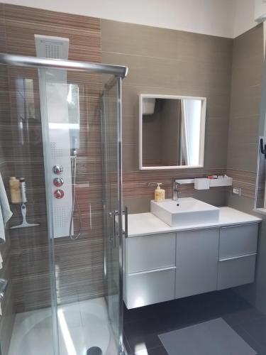 a bathroom with a glass shower and a sink at Urban Home in Pompei