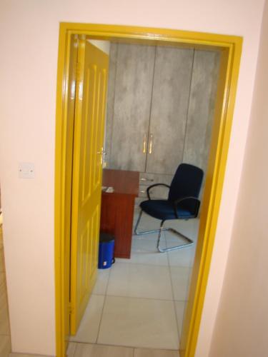 an open door to a room with a desk and a chair at Pomona BB House in Harare