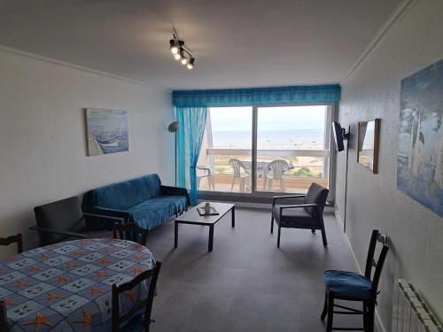 - un salon avec un canapé, un lit et une fenêtre dans l'établissement Bel appart rénové 2 ch, face mer, garage, ascenseur - FR-1-323-548, à Saint-Jean-de-Monts