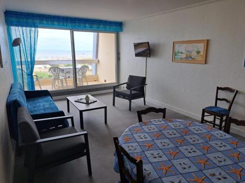 une chambre avec un lit et un salon dans l'établissement Bel appart rénové 2 ch, face mer, garage, ascenseur - FR-1-323-548, à Saint-Jean-de-Monts