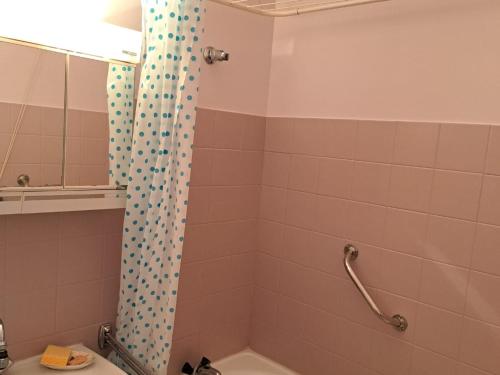 La salle de bains est pourvue d'un rideau de douche avec des points de polka. dans l'établissement Bel appart rénové 2 ch, face mer, garage, ascenseur - FR-1-323-548, à Saint-Jean-de-Monts